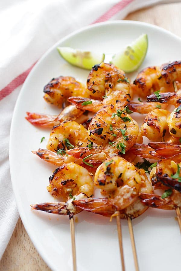 overhead view of chili lime shrimp kabobs on a white plate
