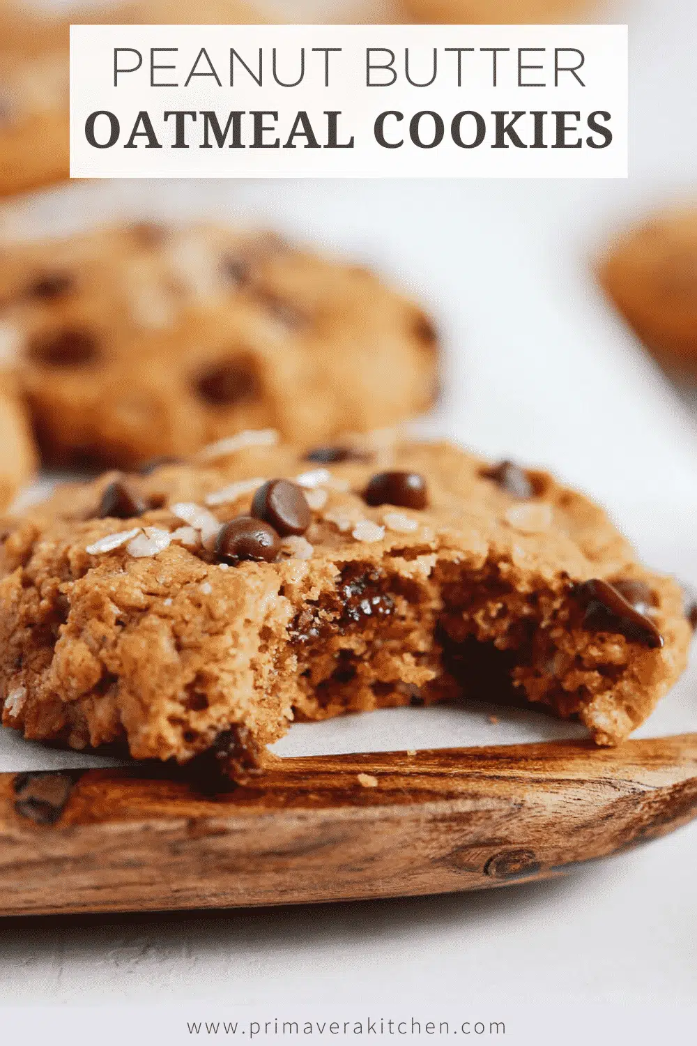 Chocolate chip cookies with a bite taken out of it on a wooden serving board