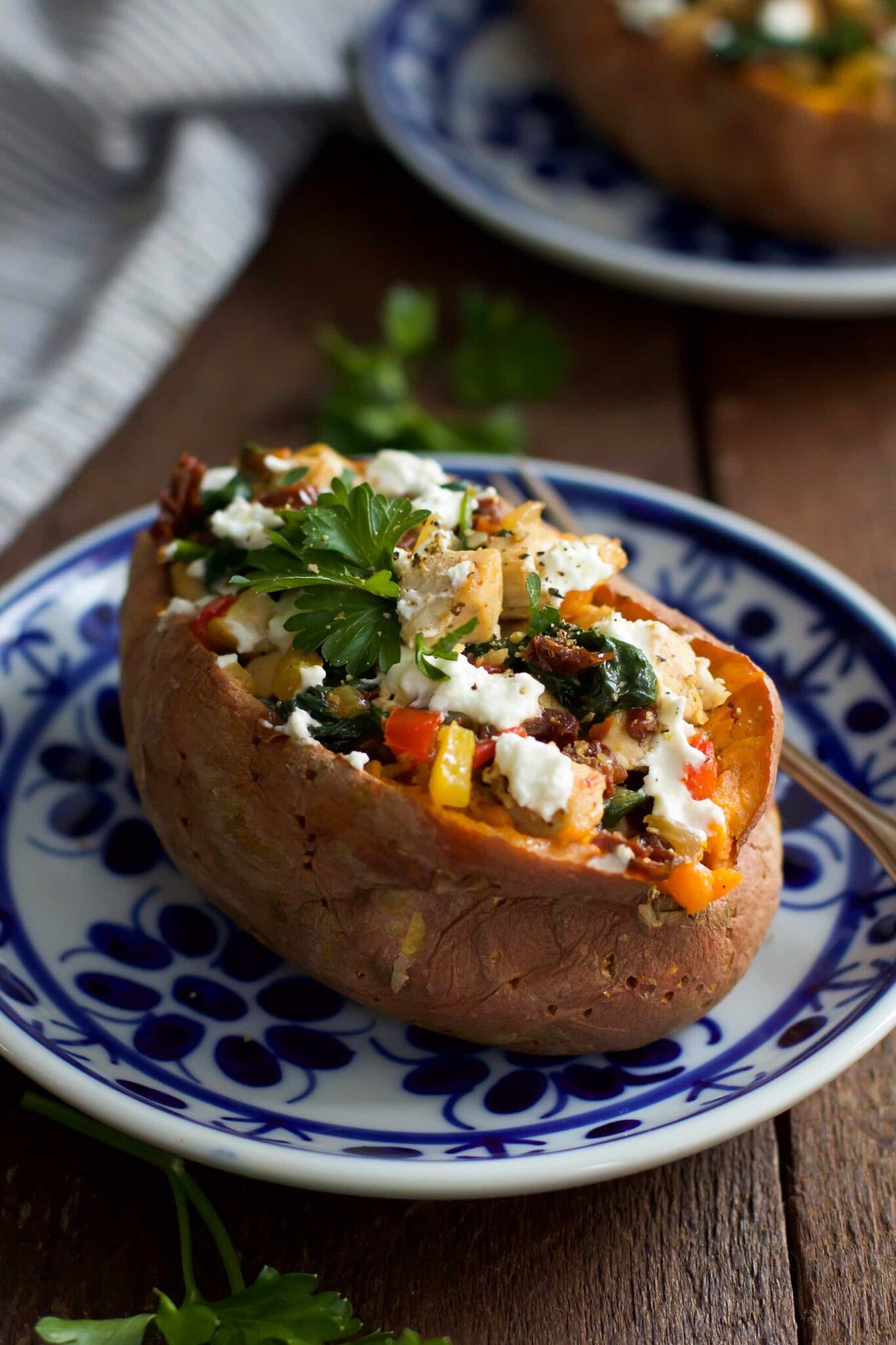 Goat cheese chicken stuffed sweet potato on a plate. 