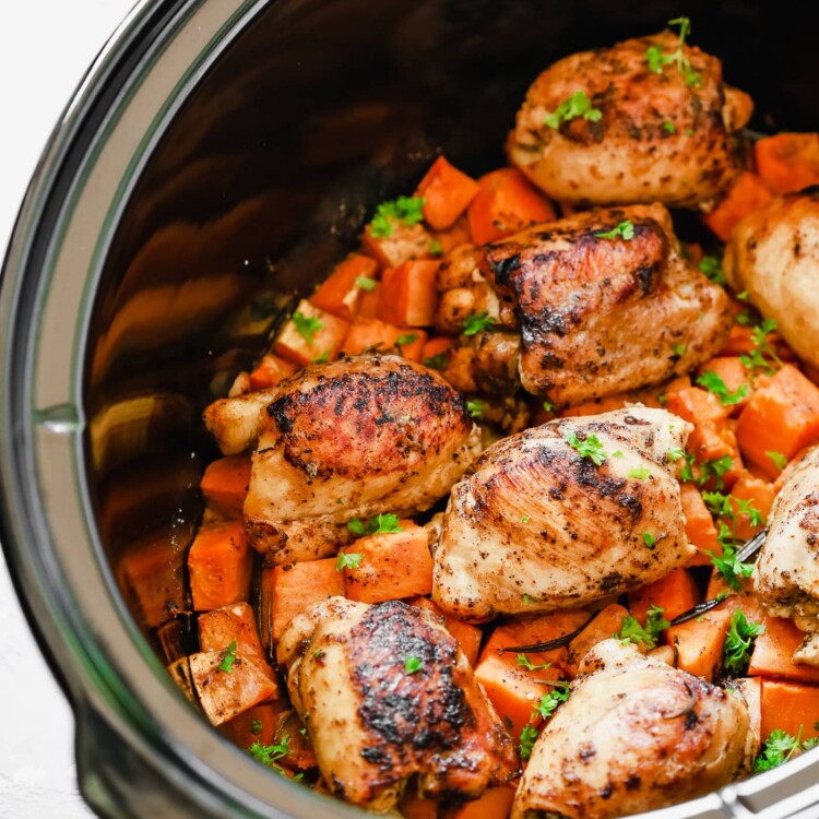 overhead view of a slow cooker pot containing sweet potato and chicken