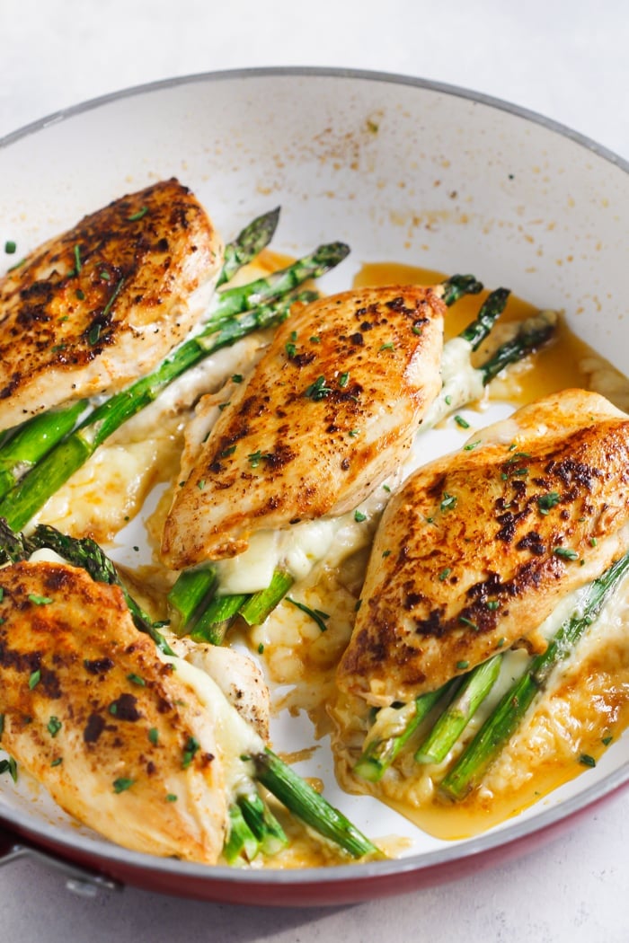 Overhead view of stuffed chicken breast in a white skillet pan