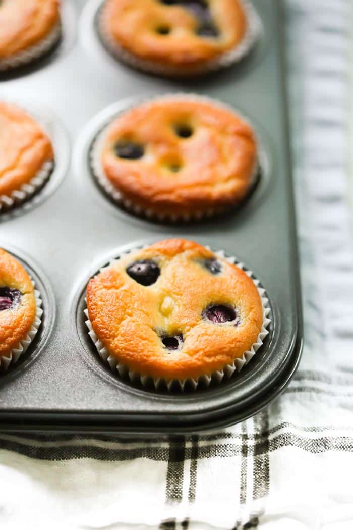 Low-carb Lemon Blueberry Blender Muffins - These Low-carb Lemon Blueberry Blender Muffins are easy, healthy, gluten-free and just 136 calories each! close-up of Low-carb Lemon Blueberry Blender Muffins in a muffin pan.