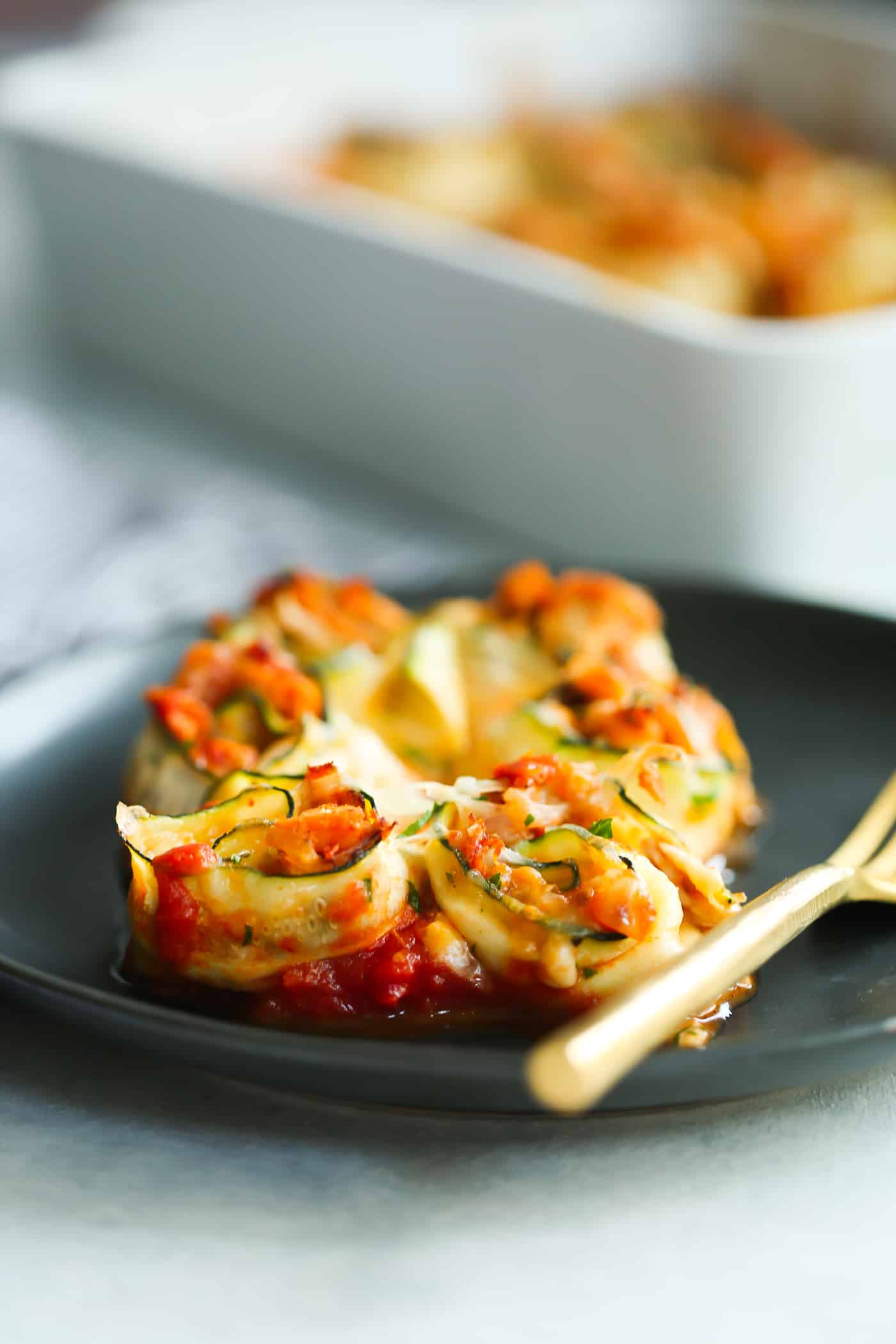 close-up of zucchini rolls on a black plate