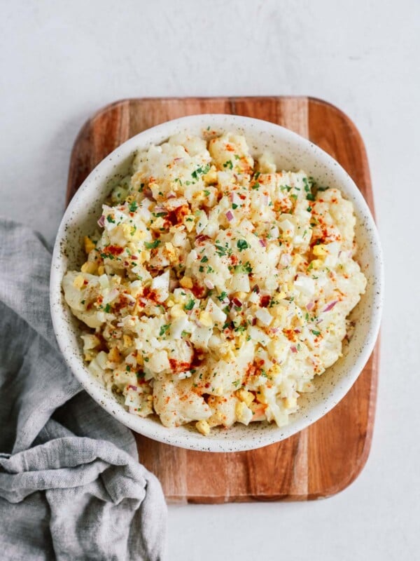 Overhead shot of cauliflower potato salad on on a wooden serving board