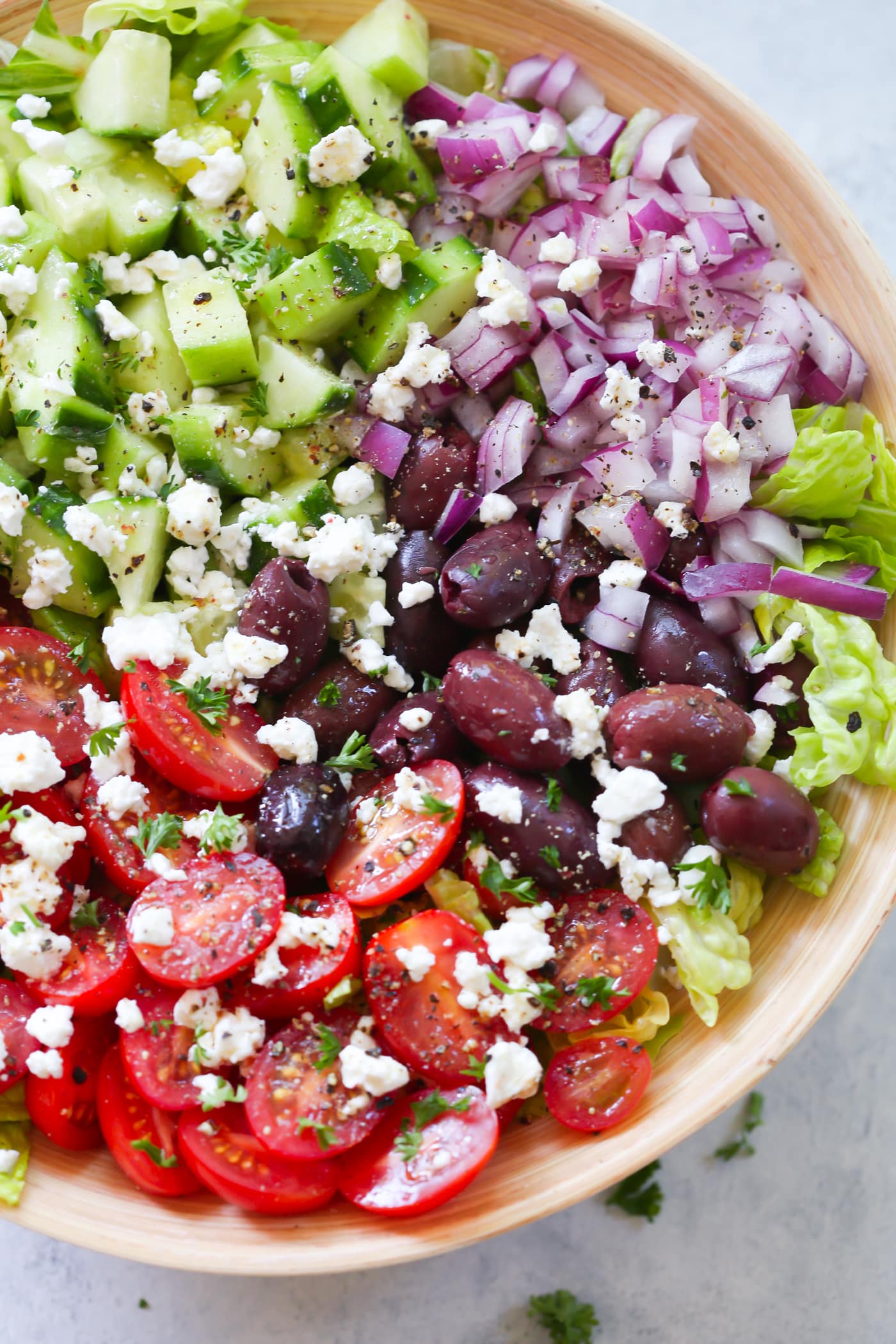 Easy Mediterranean Chopped Salad - Enjoy this Easy Mediterranean Chopped Salad made with red onions, black olives, lettuces, cucumber, cherry tomatoes, feta cheese and light lemon dressing! Mediterranean salad in a large bowl.