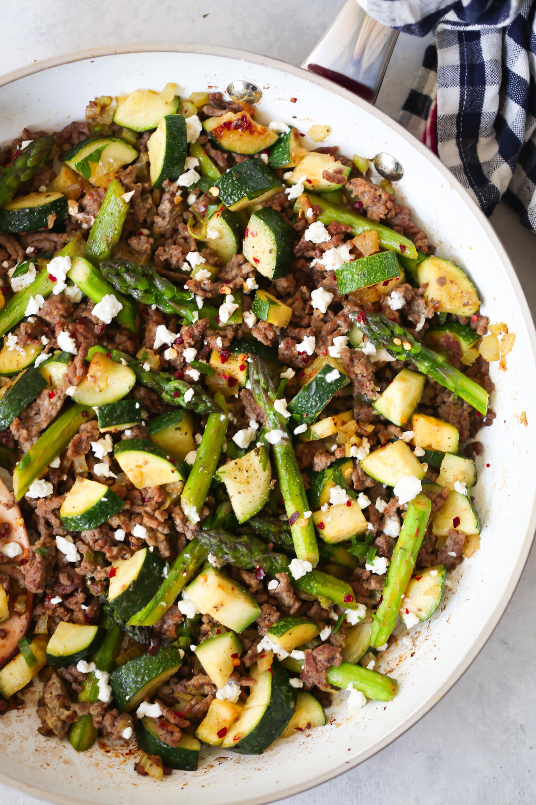 overhead view of a white skillet containing ground beef and veggies