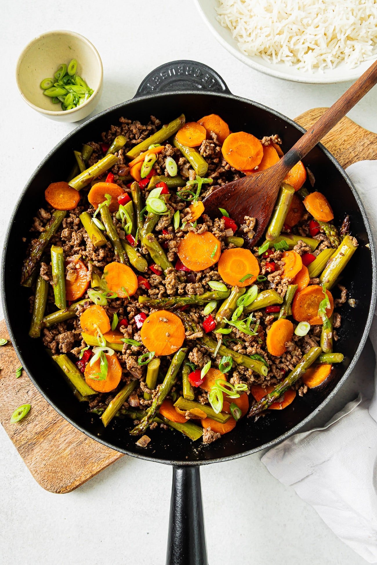 overhead view of ground beef with vegetables in a cast iron skillet.