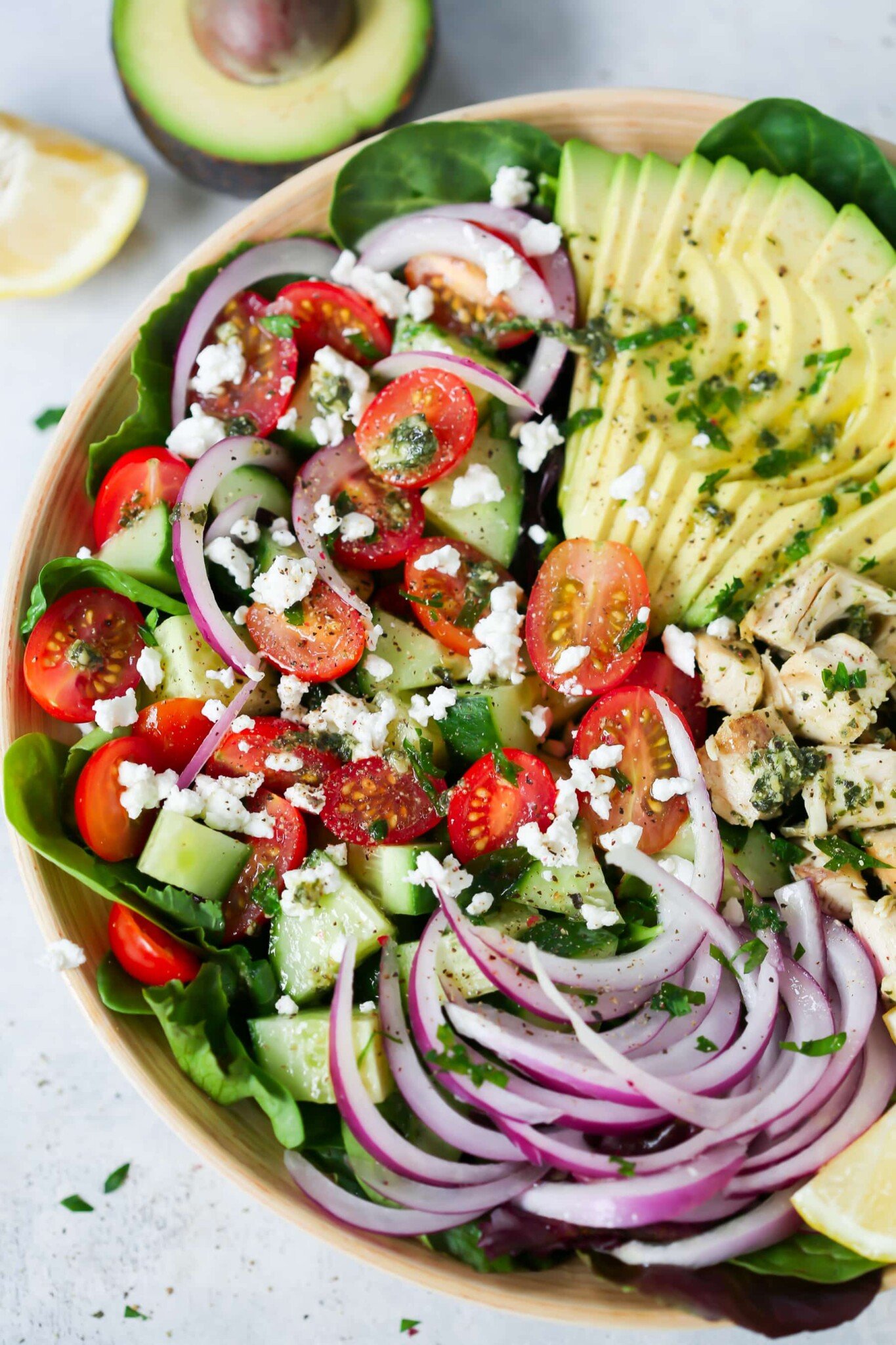 Pesto Chicken Salad - This healthy, easy, filling and super delicious Pesto Chicken Salad recipe is loaded with lettuces, cherry tomatoes, avocado, red onions and flavoured with a light lemon dressing. Pesto chicken salad in a serving bowl.
