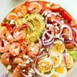 overhead view of a bowl containing shrimp avocado tomato salad.