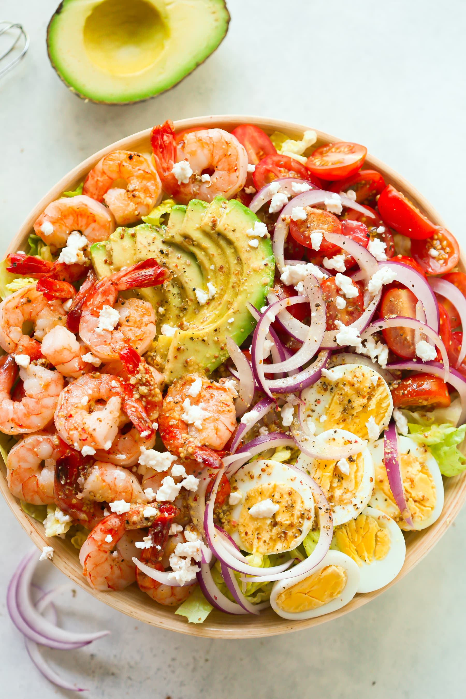 overhead view of a bowl containing shrimp avocado tomato salad. 