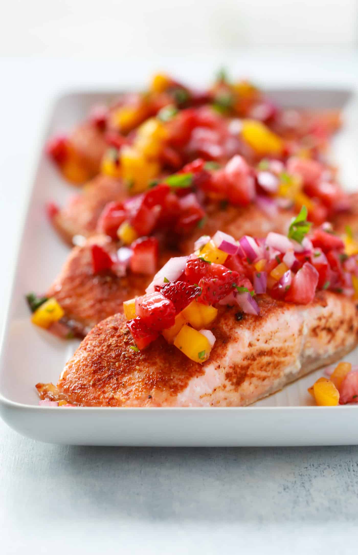 close up of 4 salmon fillets in a baking sheet