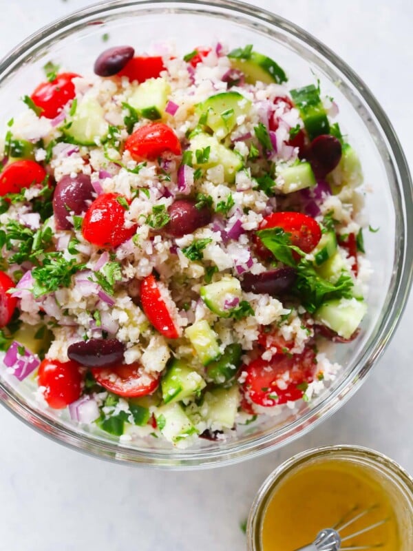 A glass bowl containing cauliflower mediterranean salad.