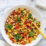 overhead view of a white bowl with peach salsa