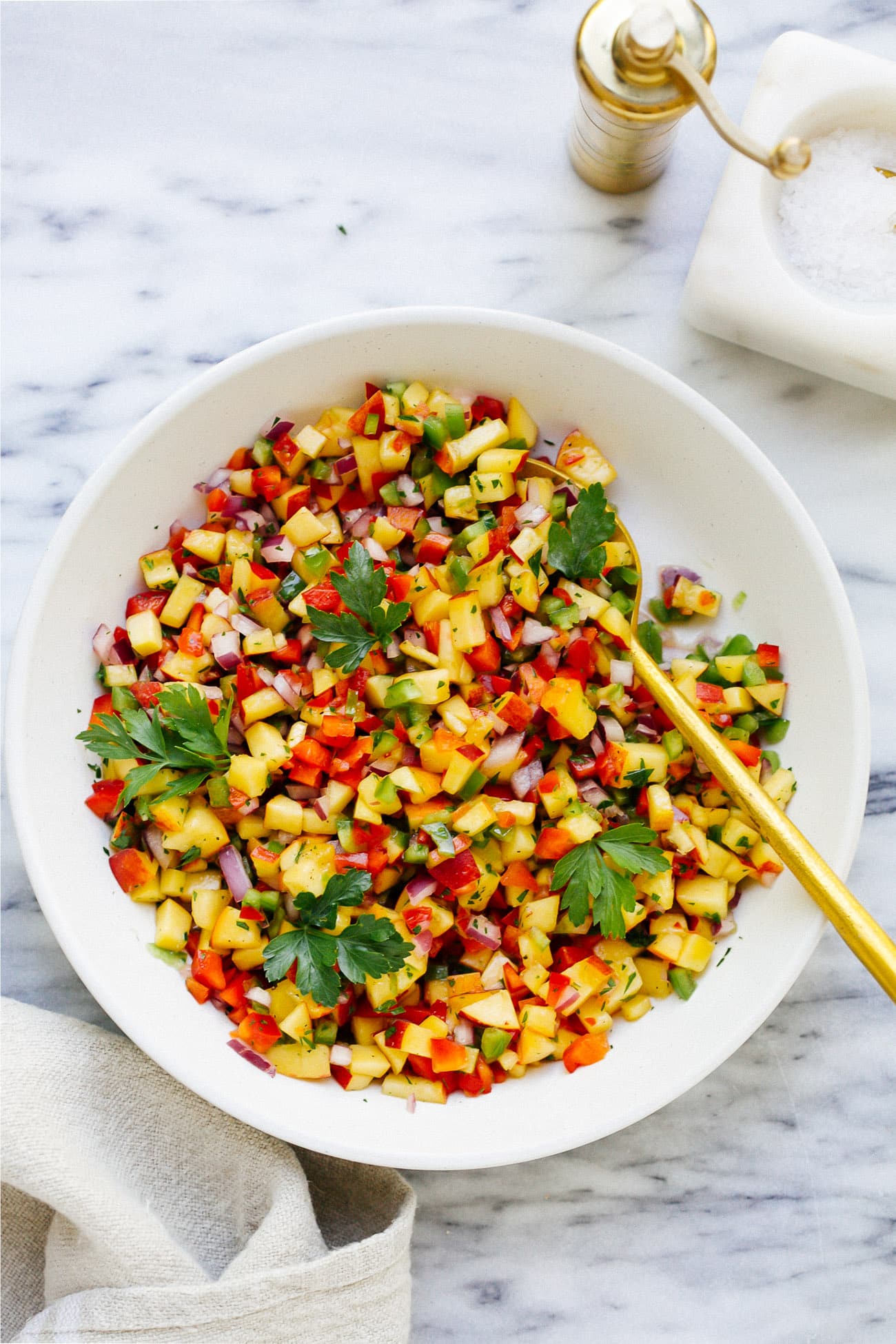 overhead view of a white bowl with peach salsa