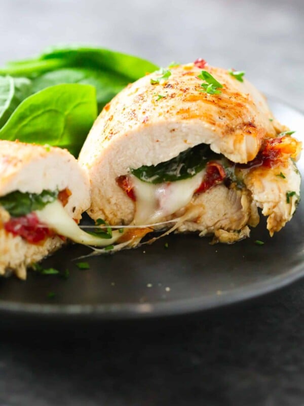 close up of a Sun Dried Tomato, Spinach and Cheese Stuffed Chicken on a black plate