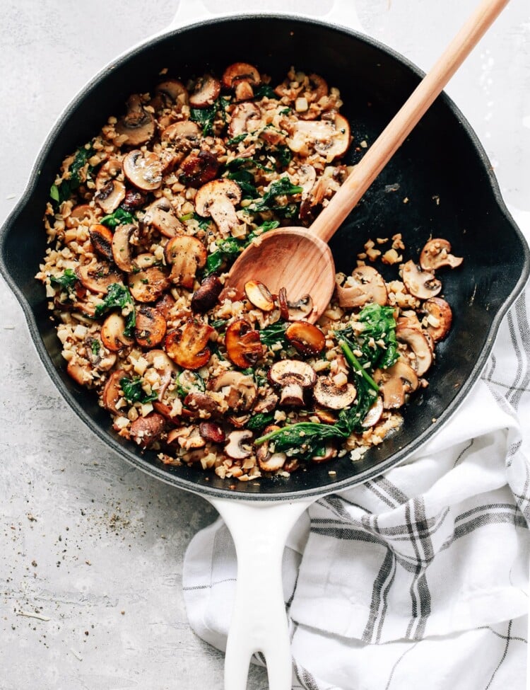 overhead view of a white skillet contains Mushroom Cauliflower Rice