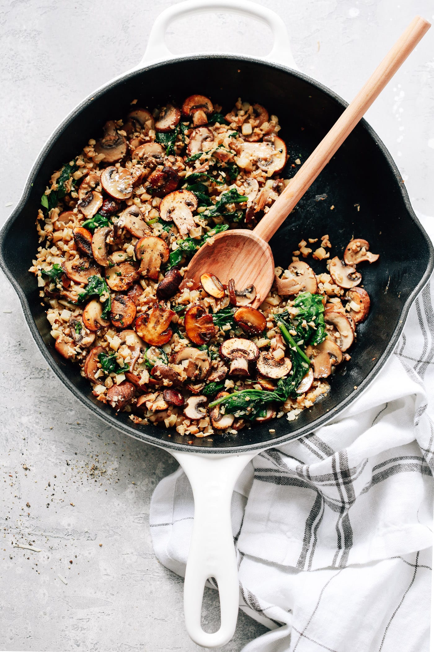 overhead view of a white skillet contains Mushroom Cauliflower Rice 