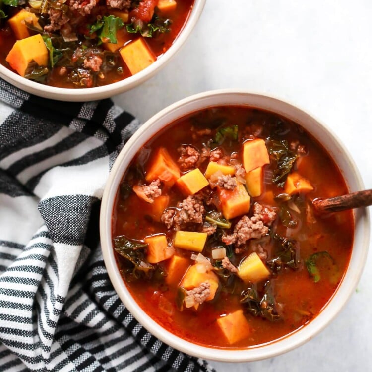 overhead view of two bowls containing Ground Beef Butternut Squash Kale Soup