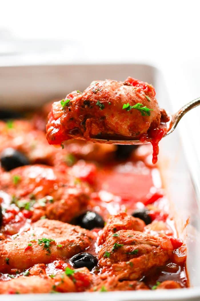close-up of chicken thigh on a large serving spoon