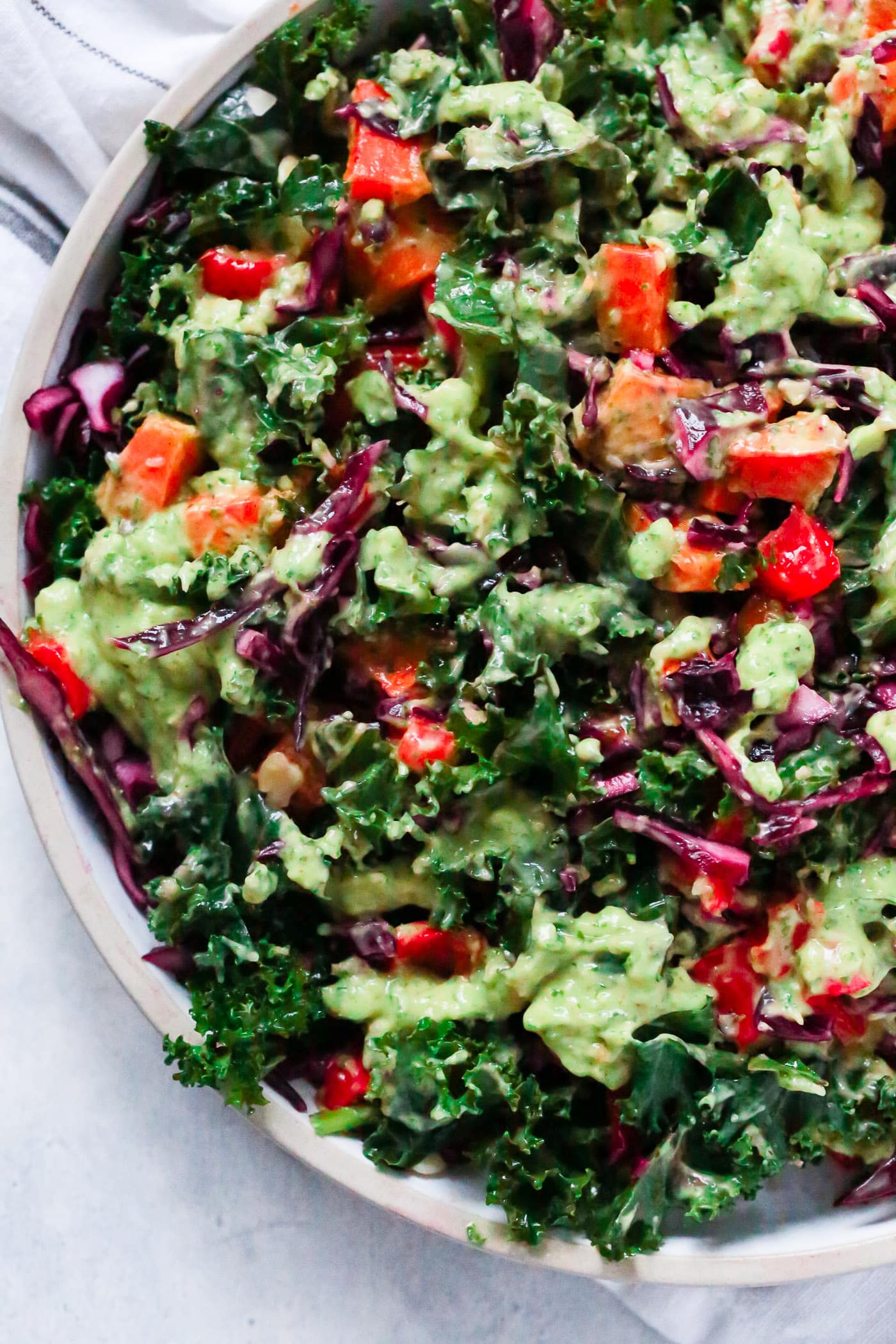 Overhead photo of a large bowl of kale salad with avocado dressing. 