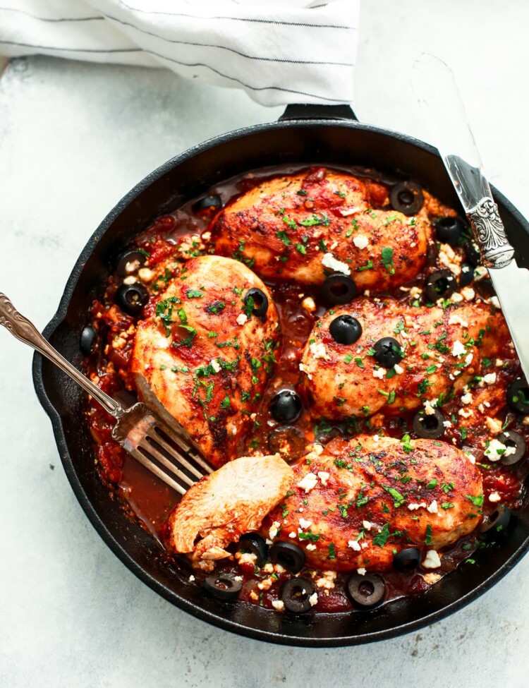 overhead view of a white skillet containing Mediterranean Chicken breast