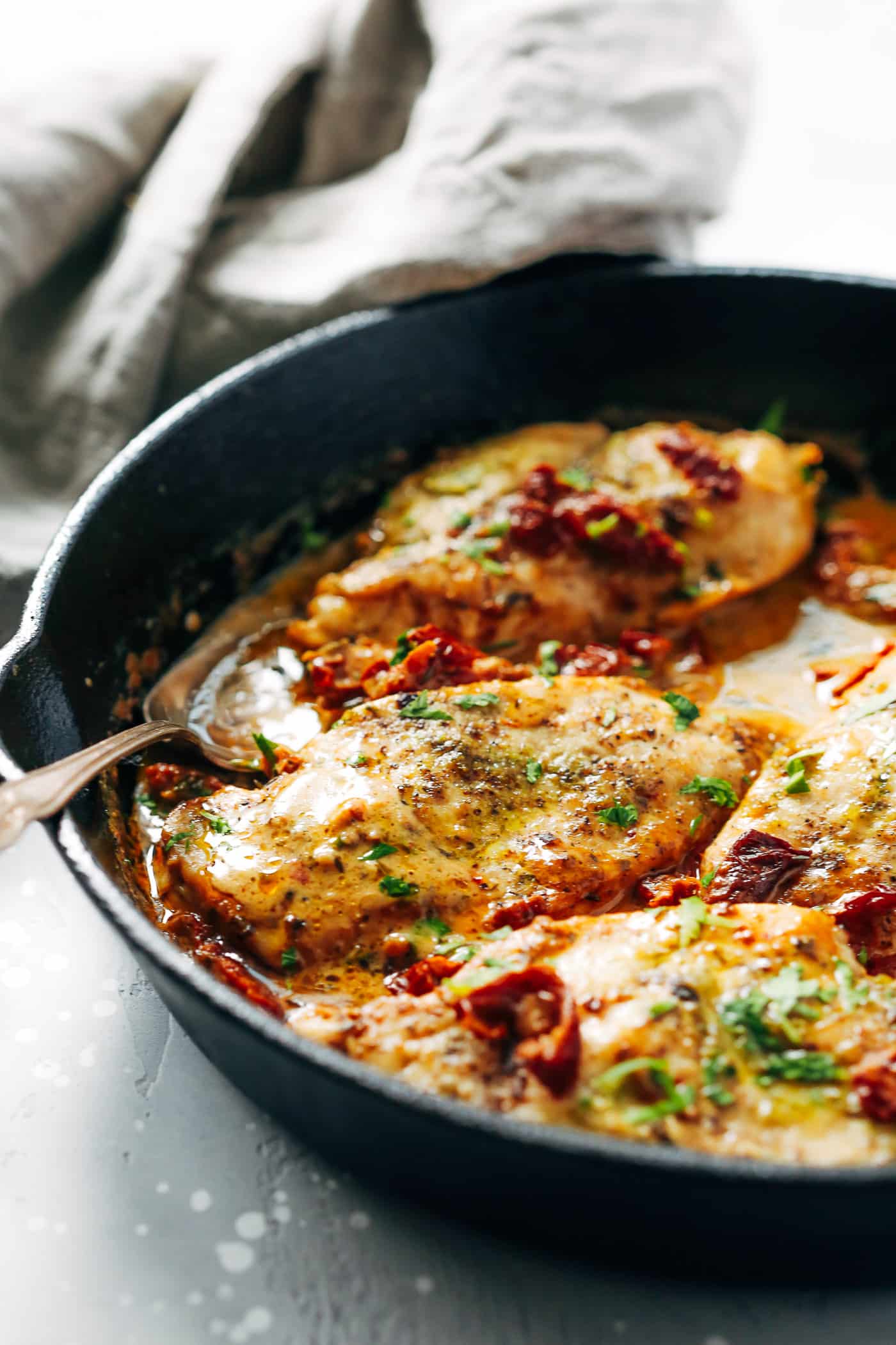 Creamy parmesan chicken in a cast iron skillet.