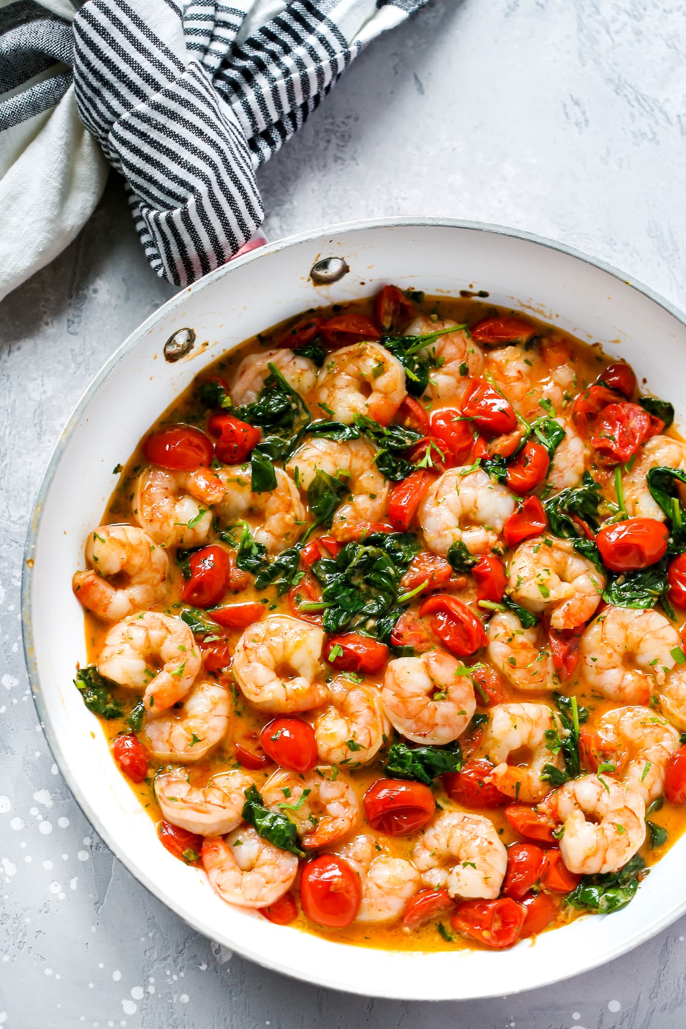 overhead view of a white skillet with creamy parmesan shrimp