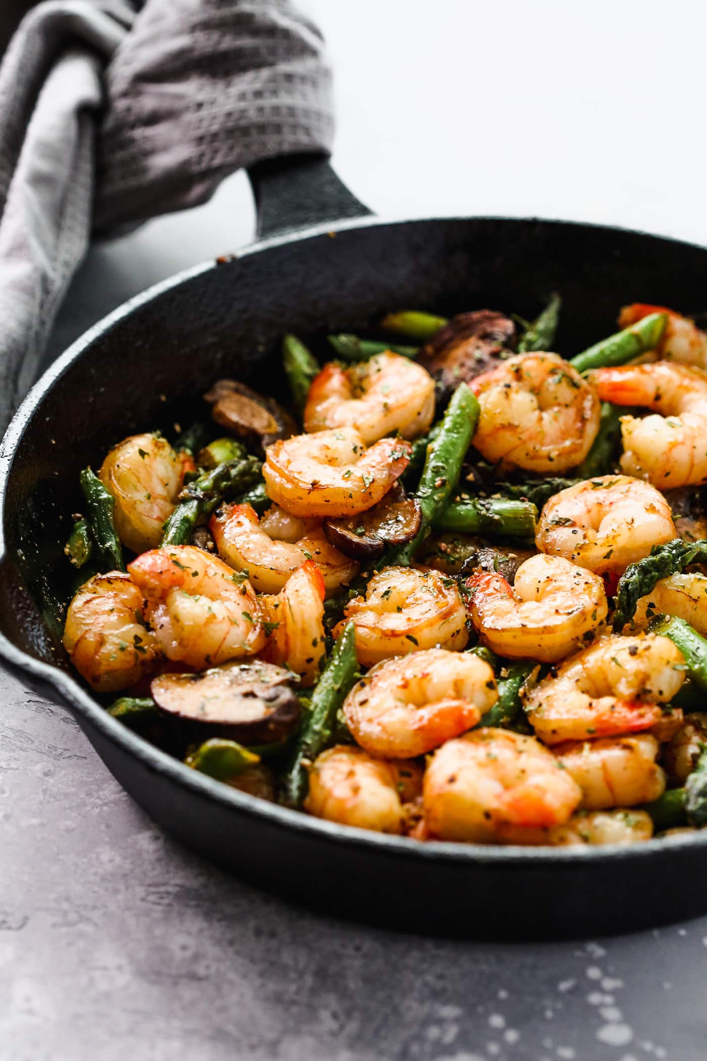 Sauteed shrimp, asparagus and mushrooms in a skillet.