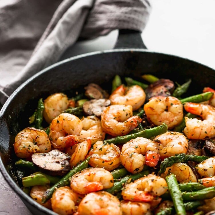 Sauteed shrimp, asparagus and mushrooms in a skillet.