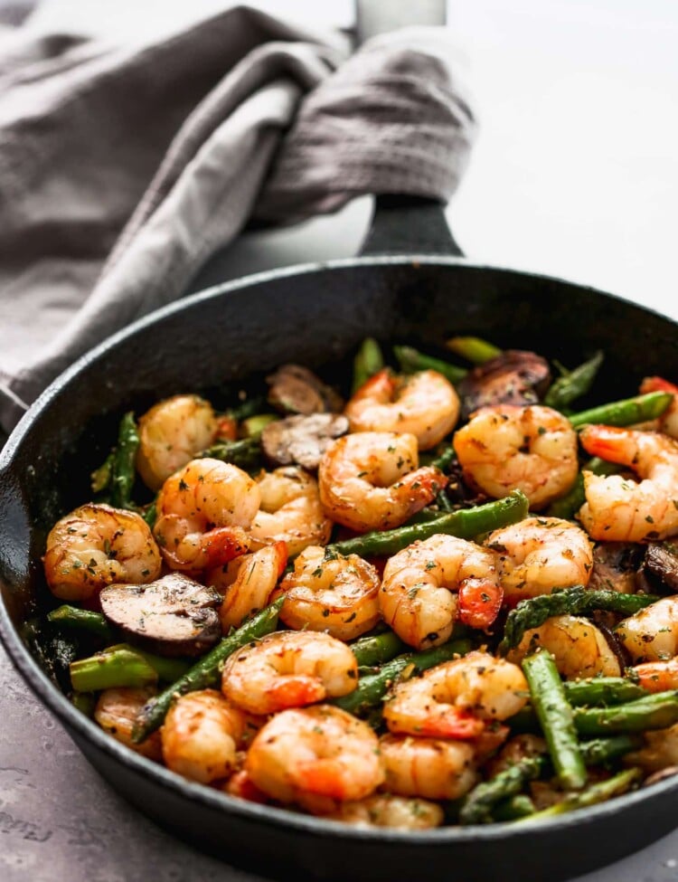 Sauteed shrimp, asparagus and mushrooms in a skillet.