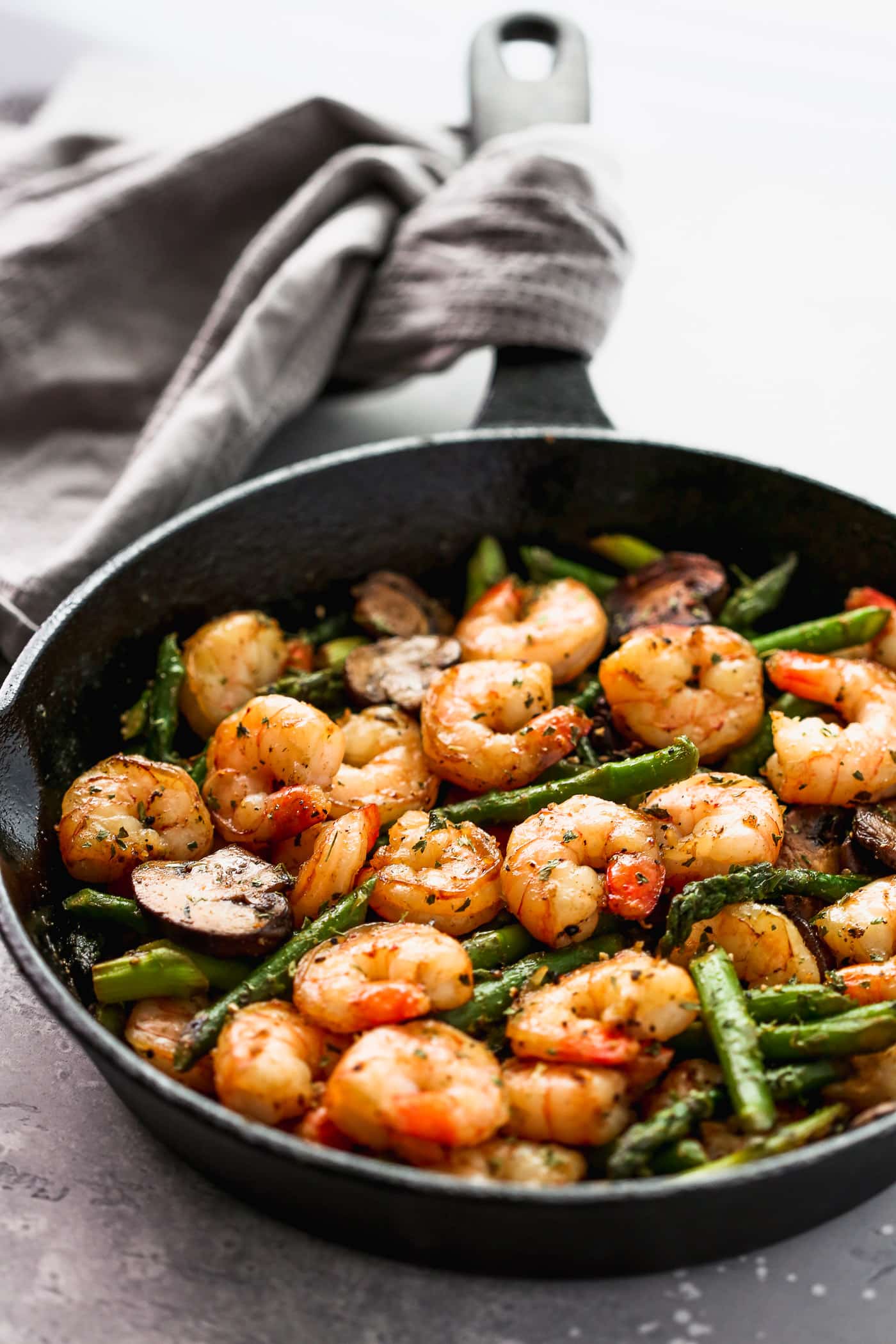 Sauteed shrimp, asparagus and mushrooms in a skillet.