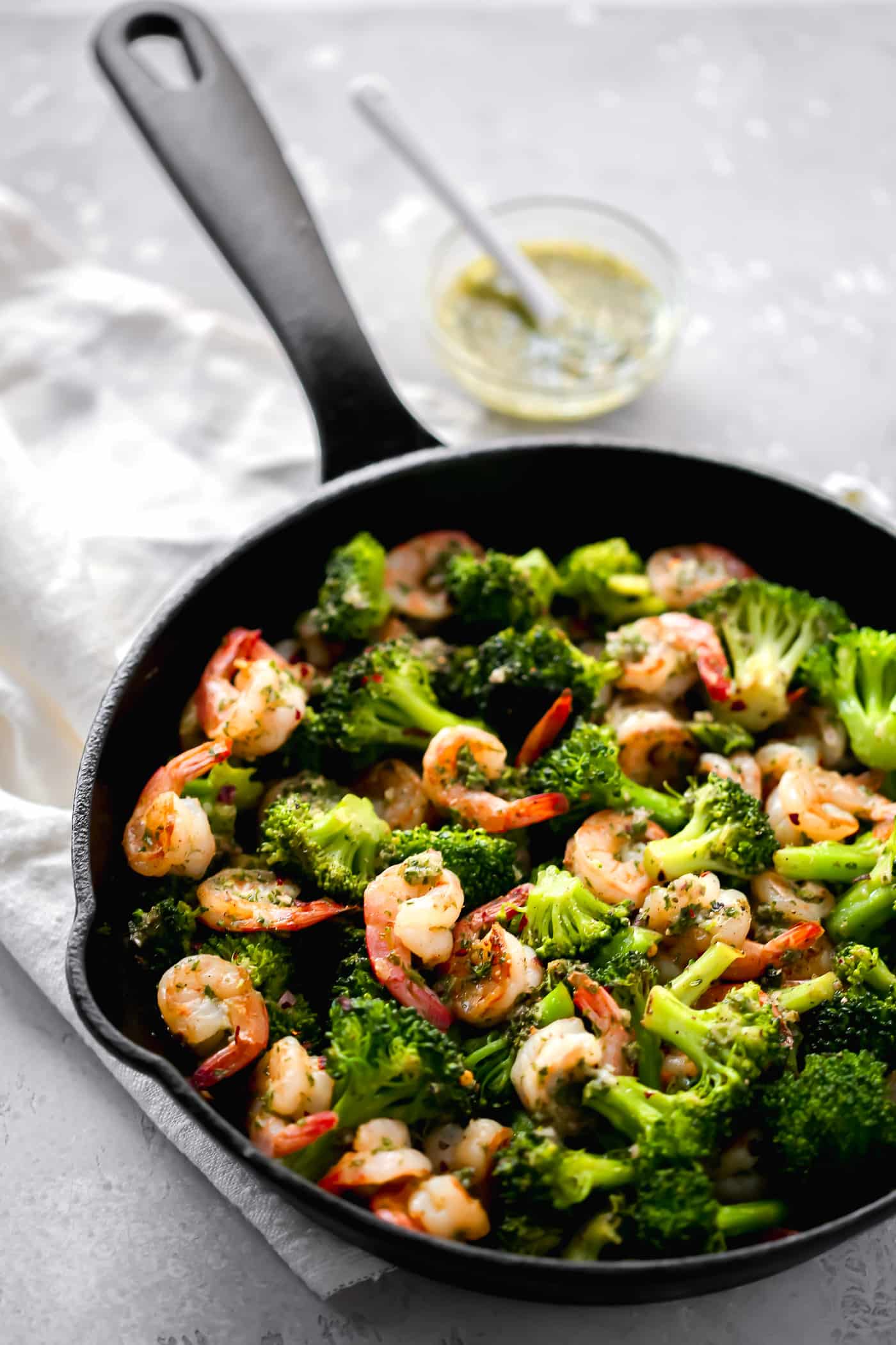 Chimichurri shrimp and broccoli in a cast-iron skillet.