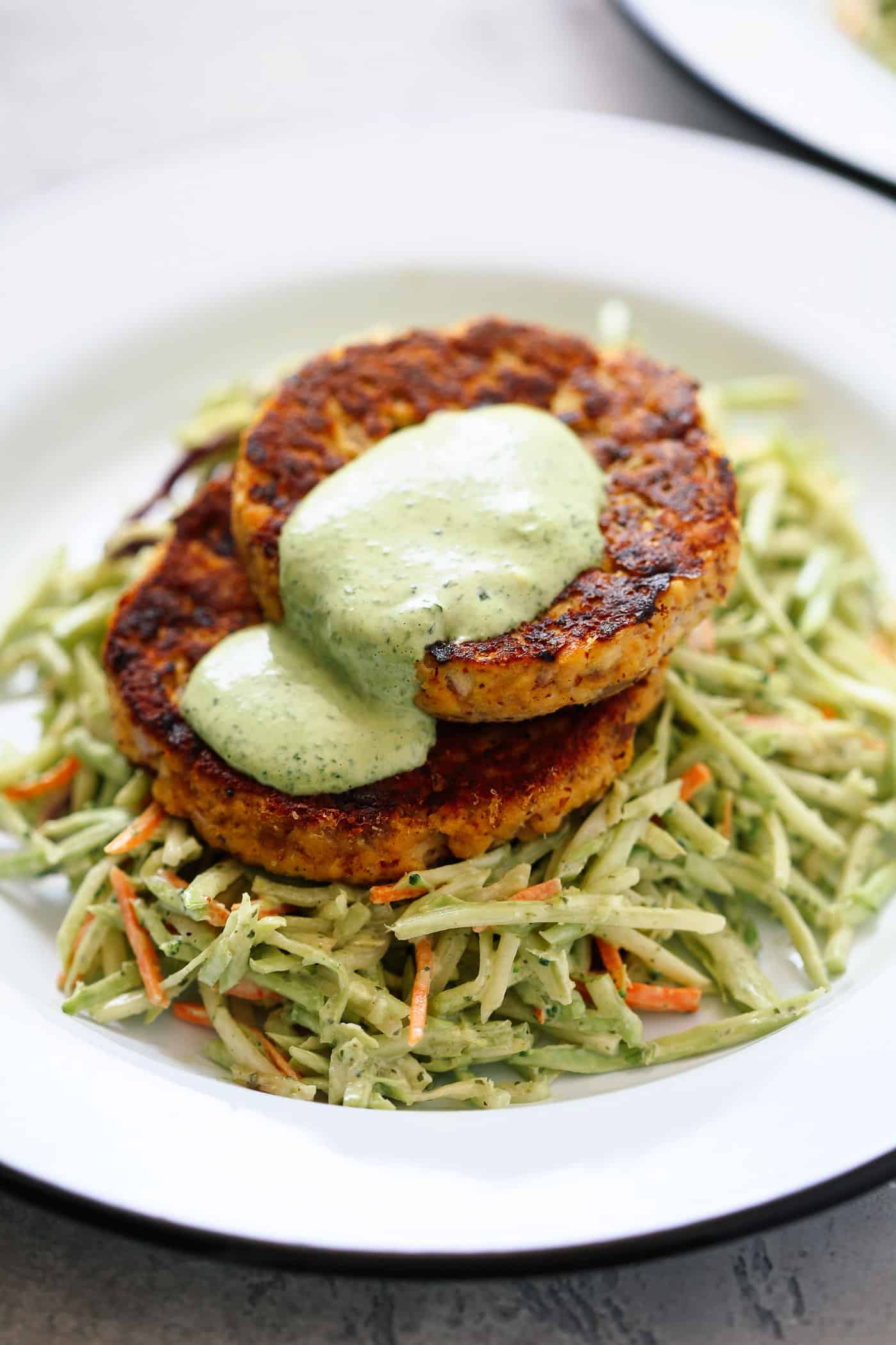 salmon patties with coleslaw salad on a white plate.