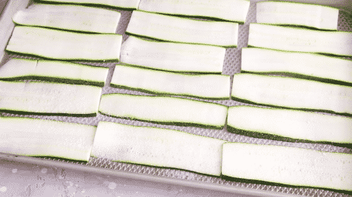 overhead view of slices of zucchini in a baking sheet
