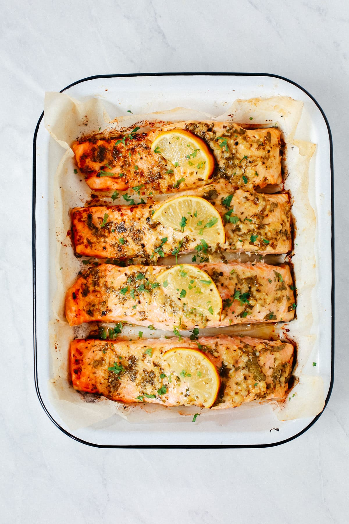 A close up of 4 pieces of salmon in a baking sheet