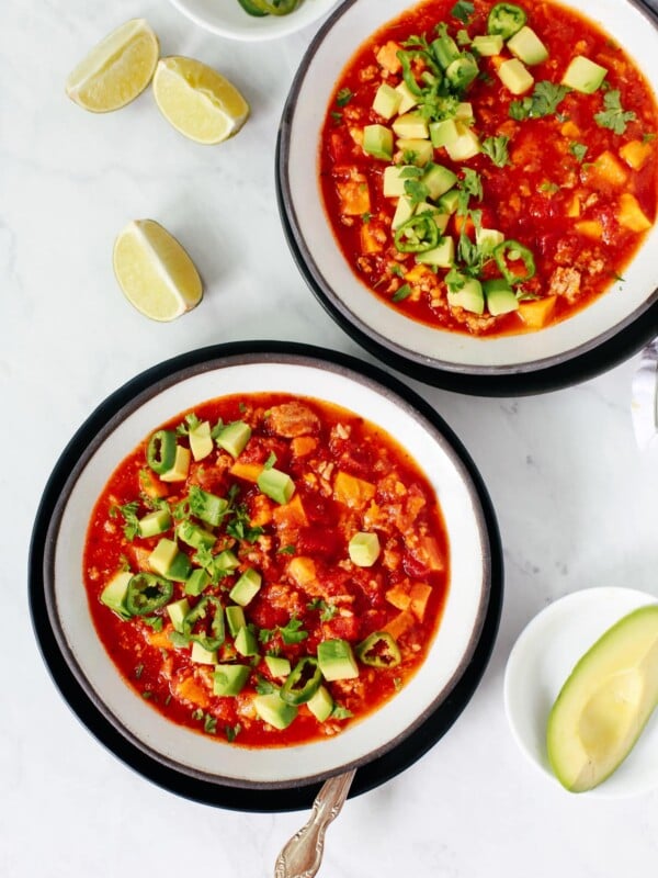 overhead view of two black rimmed bowls of pumpkin chili.