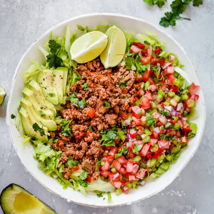 An overhead photo of a white plate of ground beef taco salad.