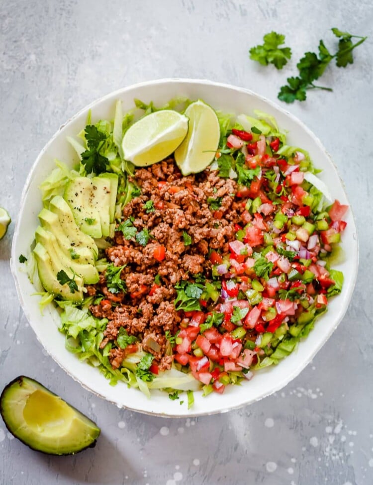 An overhead photo of a white plate of ground beef taco salad.