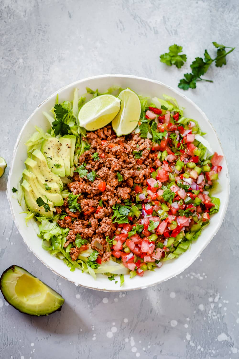 An overhead photo of a white plate of ground beef taco salad.