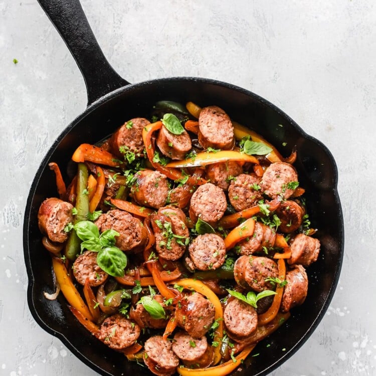 overhead view of a cast iron skillet containing sausage and bell pepper