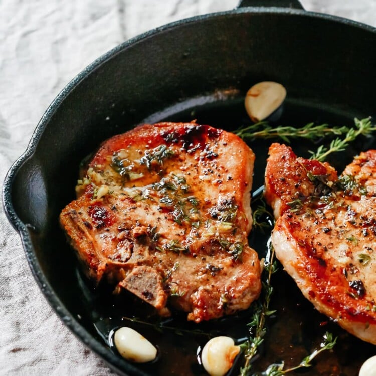 overhead view of Garlic Butter Baked Pork Chops in a cast iron skillet