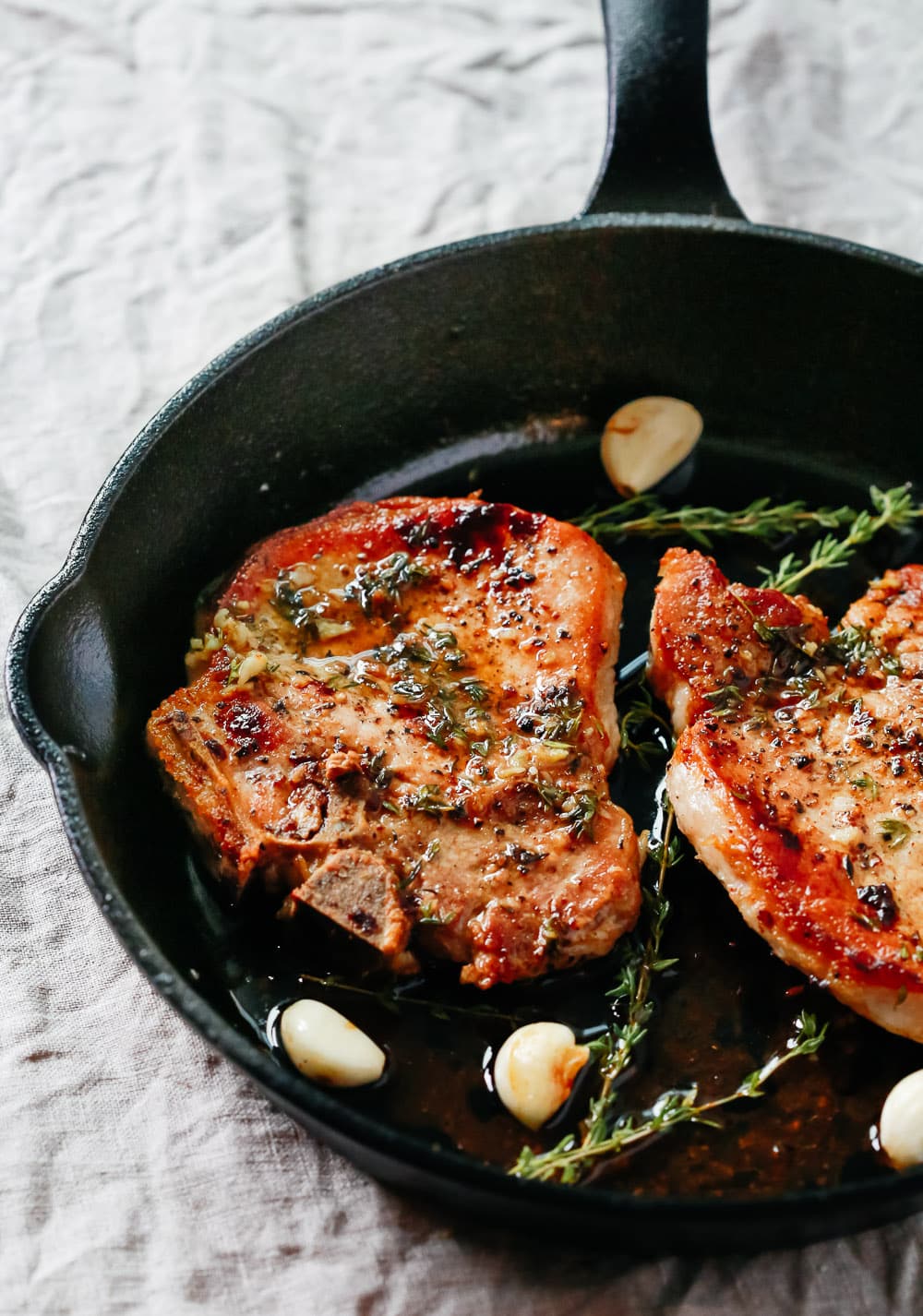 overhead view of Garlic Butter Baked Pork Chops in a cast iron skillet