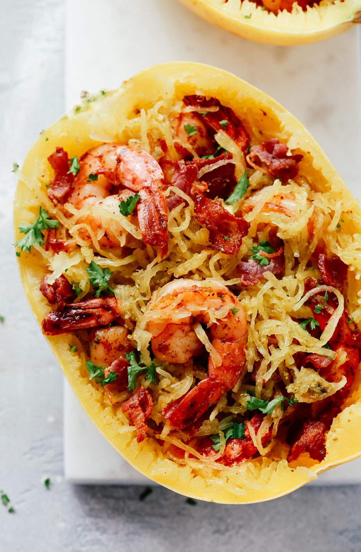 Close up image of a pesto spaghetti squash with shrimp.