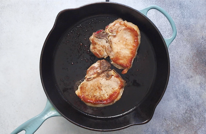 searing the pork chops in a cast iron