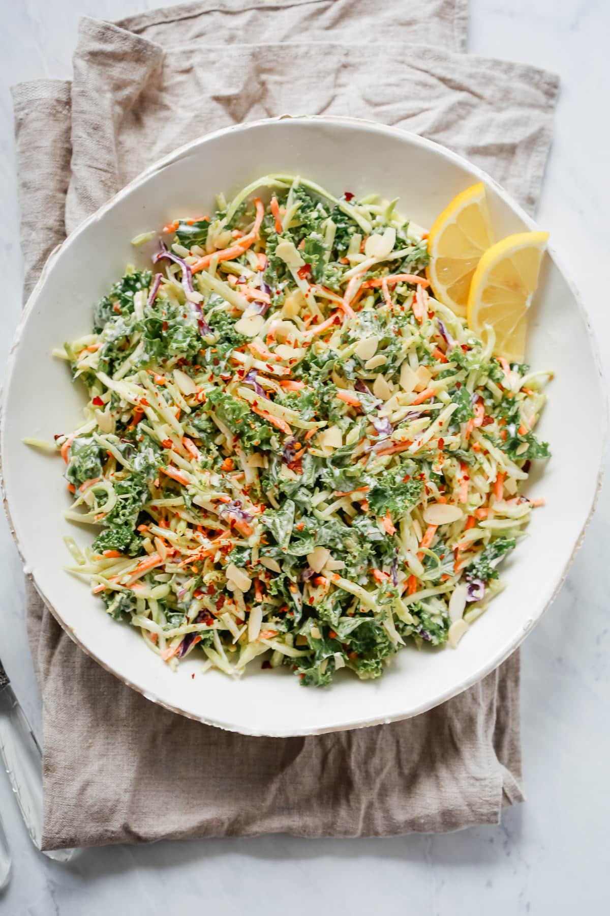 overhead view of a white bowl of broccoli kale slaw salad - Healthy Salad Recipes