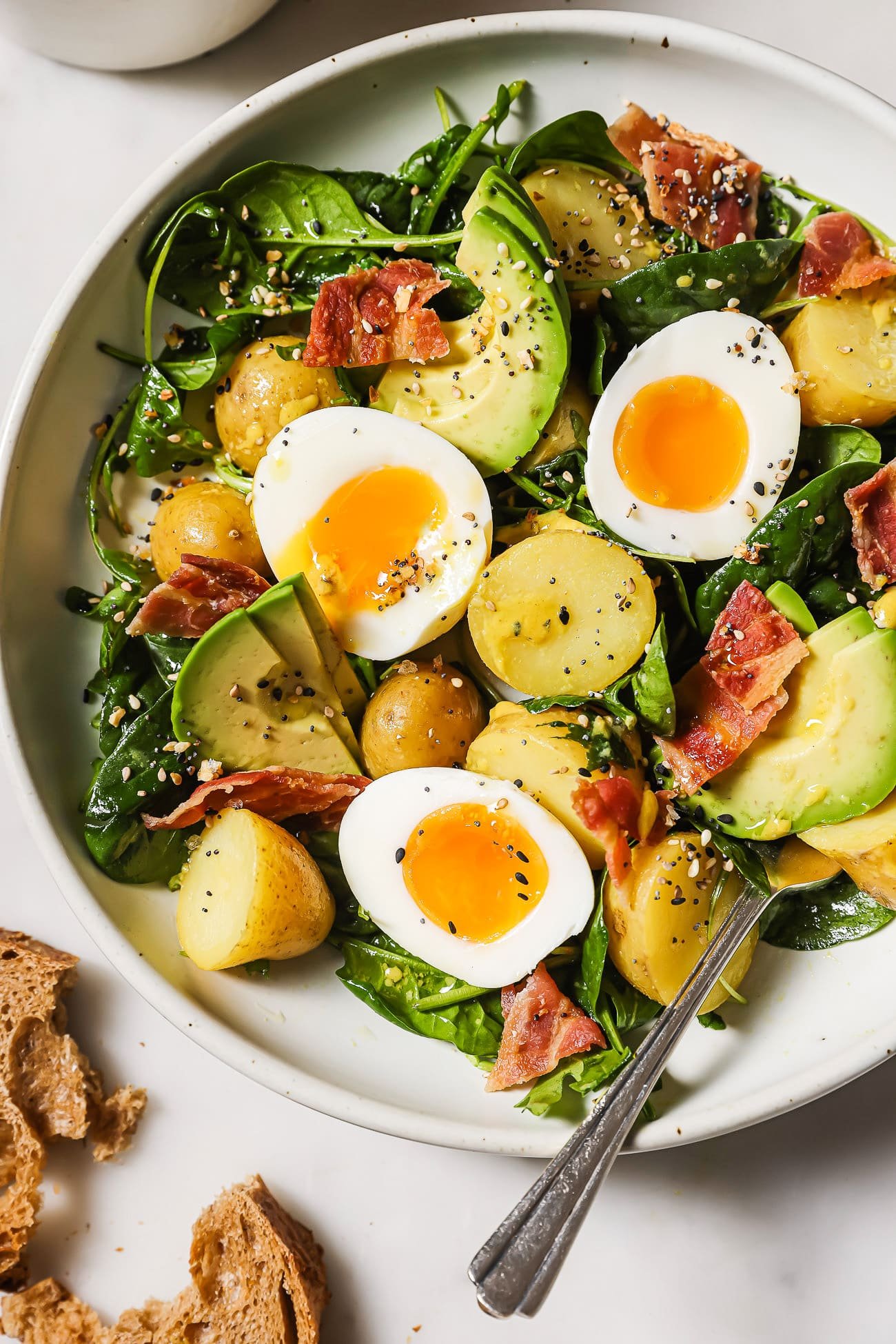 An overhead view of a breakfast salad in a white serving plate.