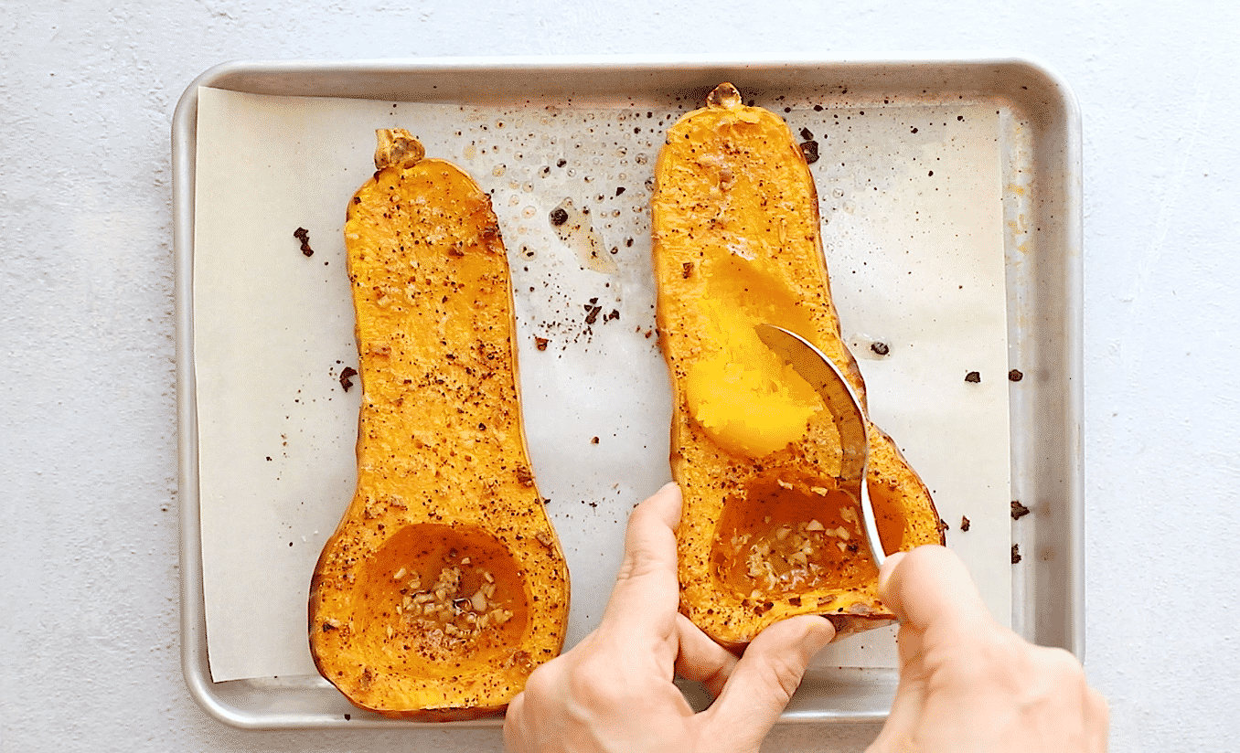 overhead view of a roasted butternut squash on a baking sheet