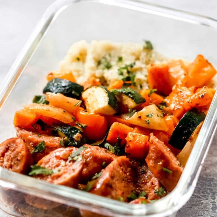 close up of a glass meal prep bowl of sausage and veggies