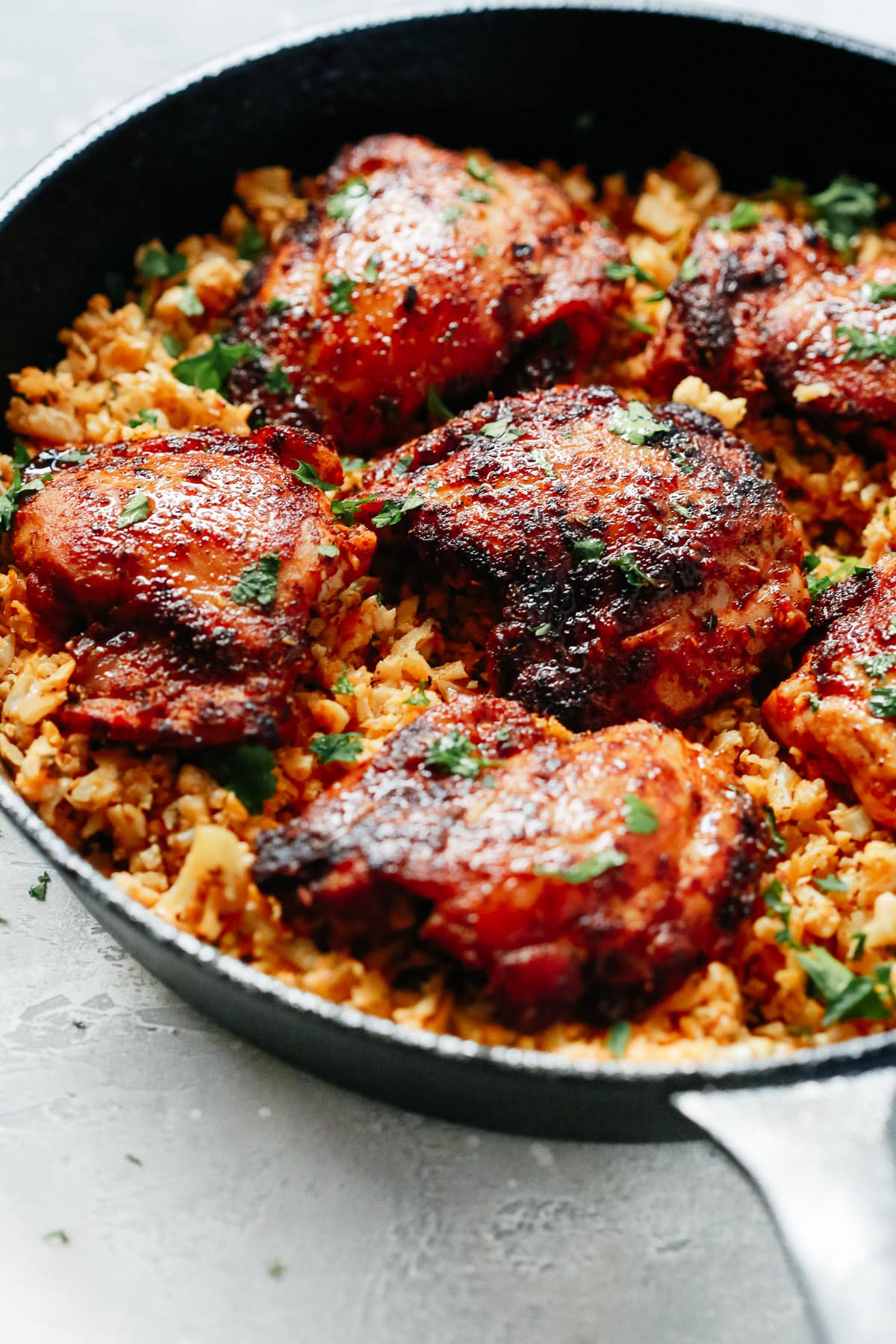 Chicken and cauliflower rice in a skillet.