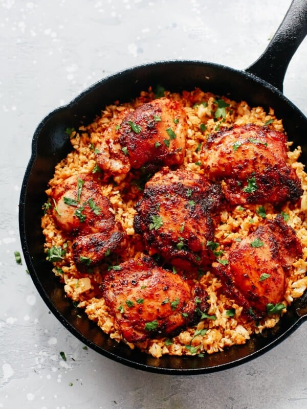 close up of a cast iron skillet containing chicken and cauliflower rice